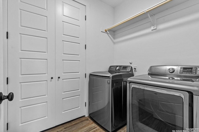 laundry room featuring laundry area, wood finished floors, and washer and clothes dryer