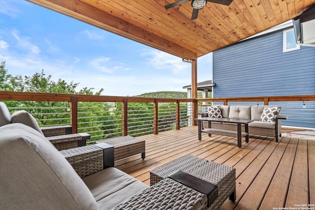 wooden terrace with an outdoor living space and a ceiling fan