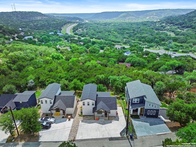 birds eye view of property with a mountain view, a residential view, and a forest view