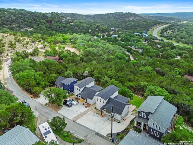 drone / aerial view featuring a residential view and a wooded view