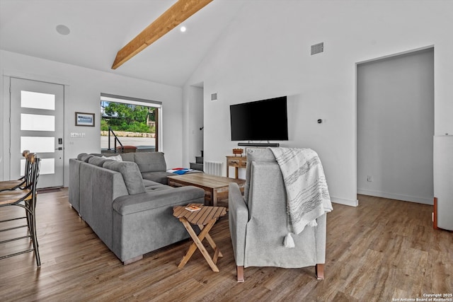 living room featuring visible vents, beam ceiling, wood finished floors, high vaulted ceiling, and baseboards