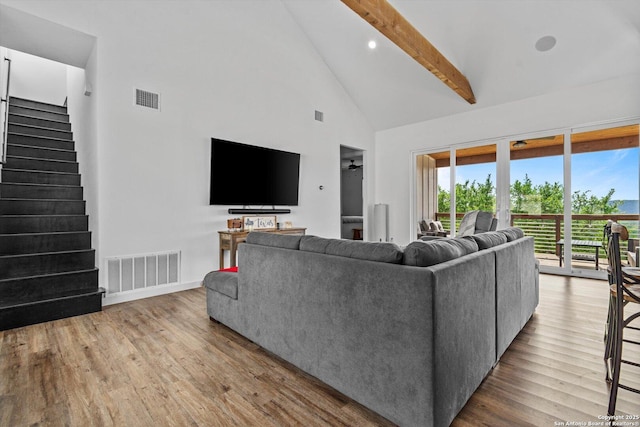 living room with visible vents, beam ceiling, wood finished floors, and high vaulted ceiling