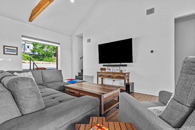 living area with visible vents, stairs, wood finished floors, and high vaulted ceiling
