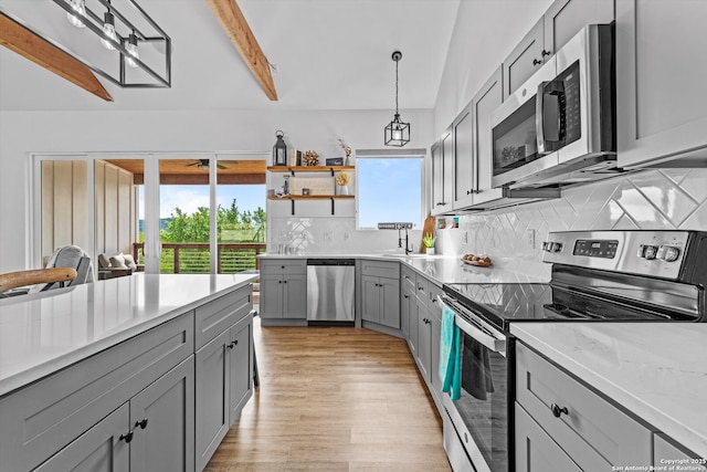 kitchen with plenty of natural light, light wood-type flooring, gray cabinets, and stainless steel appliances