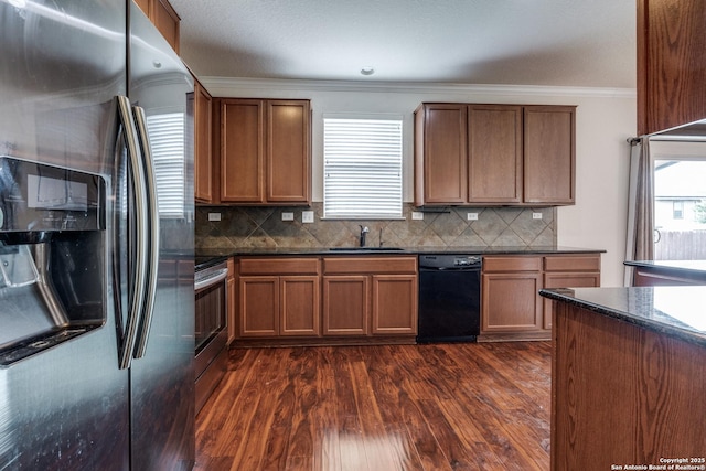kitchen with appliances with stainless steel finishes, a sink, dark wood finished floors, tasteful backsplash, and ornamental molding