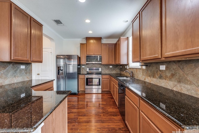 kitchen featuring visible vents, ornamental molding, dark wood-style flooring, tasteful backsplash, and stainless steel appliances