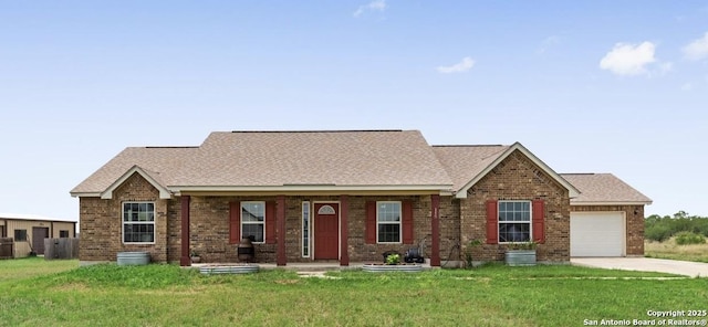 view of front of property with a garage, driveway, brick siding, and a front yard
