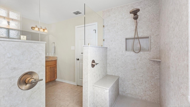 bathroom with visible vents, a walk in shower, tile patterned floors, and vanity