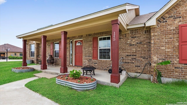 view of front of home with covered porch, brick siding, and a front yard