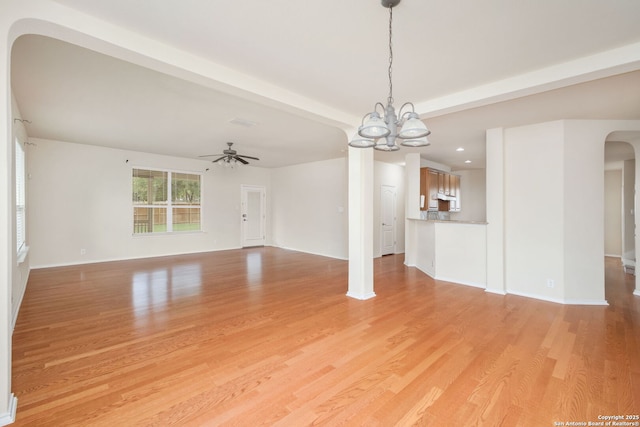 5803 Sugarberry, San Antonio, TX 78253 - unfurnished living room featuring arched walkways, ceiling fan with notable chandelier, recessed lighting, baseboards, and light wood-type flooring