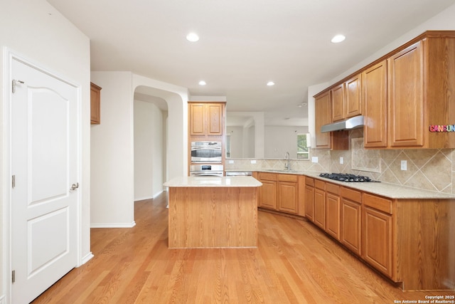 5803 Sugarberry, San Antonio, TX 78253 - kitchen with a sink, light countertops, decorative backsplash, and under cabinet range hood