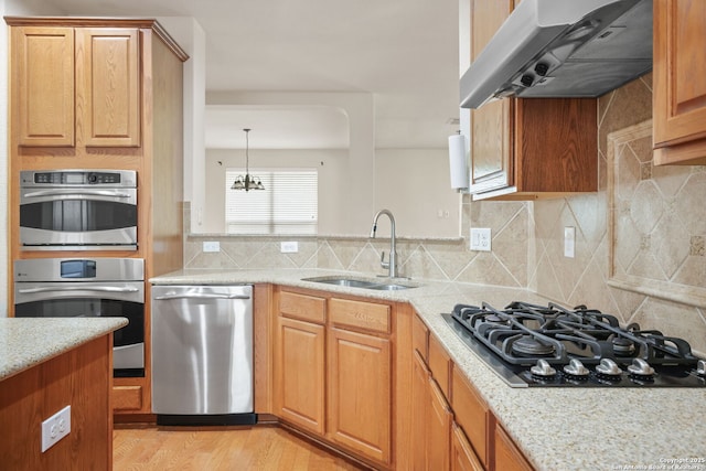 5803 Sugarberry, San Antonio, TX 78253 - kitchen featuring a sink, light stone counters, under cabinet range hood, an inviting chandelier, and stainless steel appliances