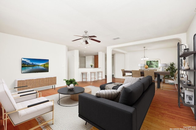 5803 Sugarberry, San Antonio, TX 78253 - living area featuring ceiling fan with notable chandelier, light wood finished floors, and visible vents