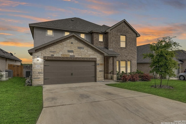 traditional-style house with central AC unit, a garage, a front lawn, and concrete driveway