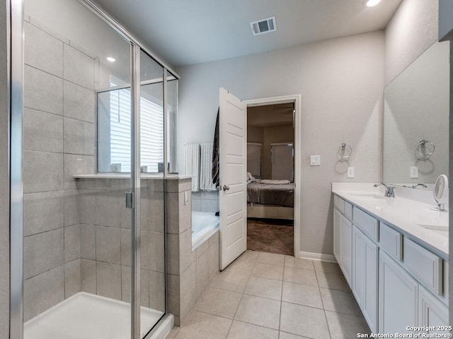 ensuite bathroom featuring visible vents, tile patterned flooring, a stall shower, a sink, and ensuite bathroom