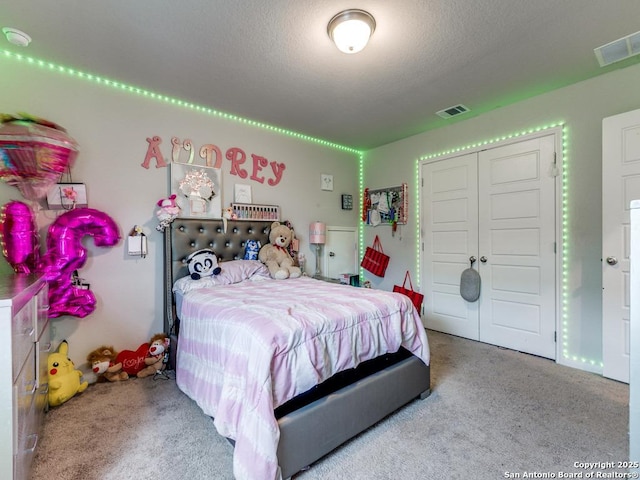 carpeted bedroom with visible vents and a closet