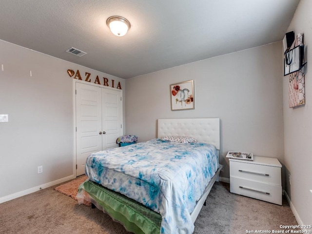 bedroom with baseboards, light carpet, a closet, and visible vents
