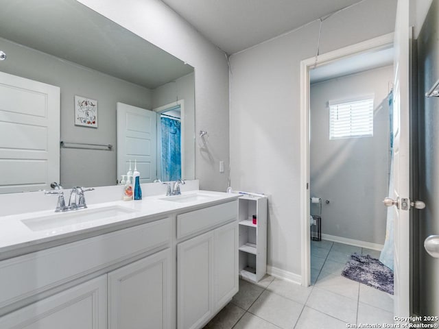 full bath with double vanity, a sink, baseboards, and tile patterned floors