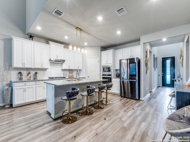 kitchen featuring a sink, stainless steel appliances, recessed lighting, under cabinet range hood, and visible vents