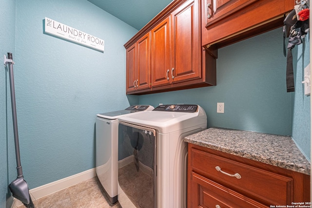 washroom featuring baseboards, cabinet space, and washing machine and clothes dryer