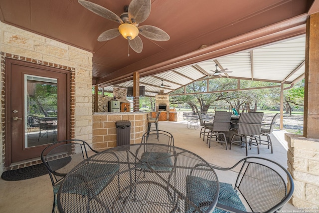 view of patio featuring ceiling fan, a bar, and outdoor dining space