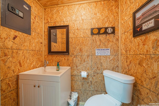 bathroom featuring toilet, tile walls, and vanity