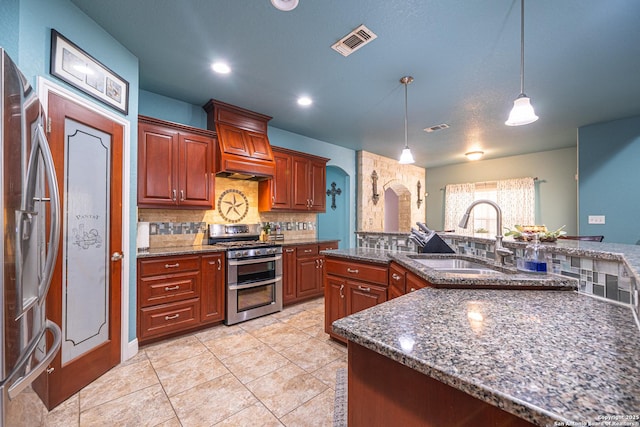 kitchen with appliances with stainless steel finishes, tasteful backsplash, arched walkways, hanging light fixtures, and a sink