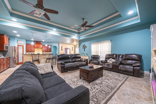 living room featuring crown molding, ceiling fan, a raised ceiling, arched walkways, and recessed lighting