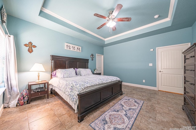 bedroom with baseboards, crown molding, a tray ceiling, and ceiling fan