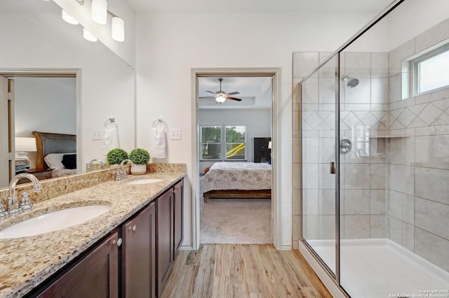 bathroom with a sink, ensuite bath, wood finished floors, and a wealth of natural light