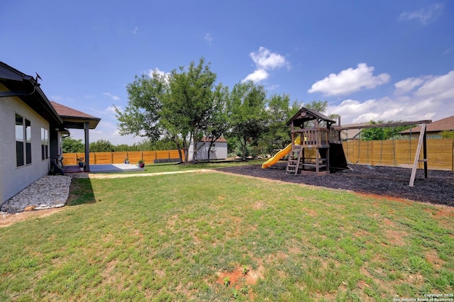 view of yard featuring a fenced backyard, an outdoor structure, a playground, and a shed
