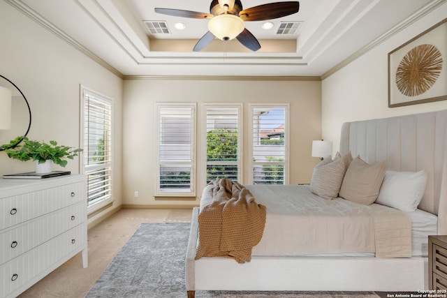 bedroom featuring visible vents, a raised ceiling, crown molding, and light carpet