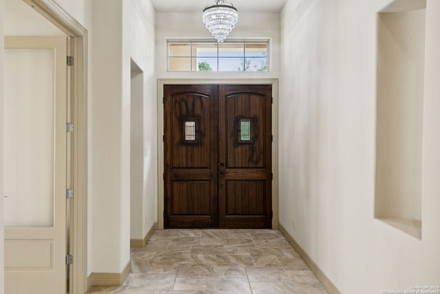 entryway with baseboards and an inviting chandelier
