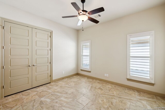 unfurnished bedroom with visible vents, baseboards, ceiling fan, and a closet