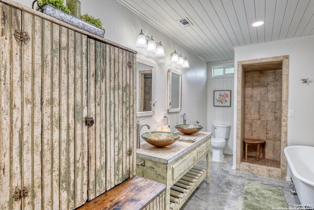 full bathroom with a sink, a freestanding tub, ornamental molding, and toilet
