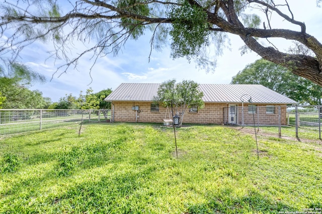 exterior space with a lawn, fence, and metal roof