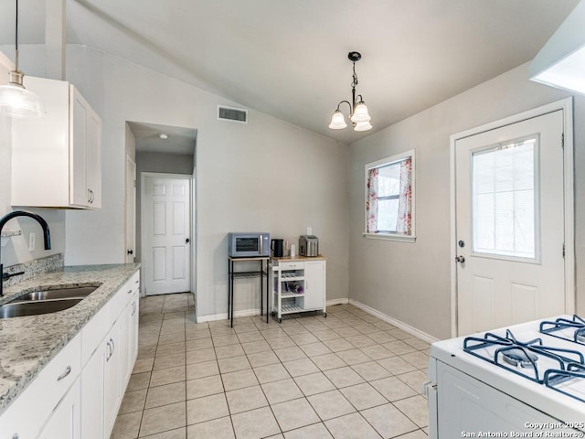 kitchen featuring visible vents, lofted ceiling, white range with gas cooktop, white cabinets, and a sink