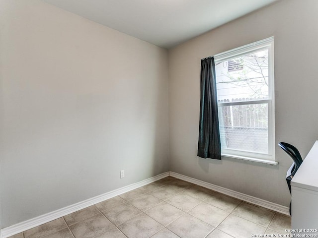 empty room featuring light tile patterned floors and baseboards