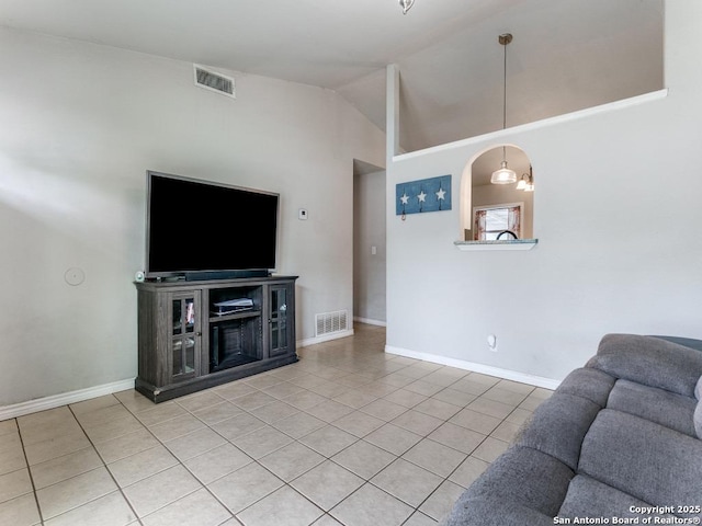 living area featuring baseboards, visible vents, light tile patterned floors, and high vaulted ceiling