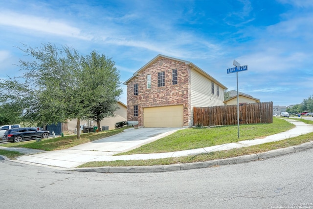 traditional-style home featuring driveway, a front yard, a garage, fence, and stone siding