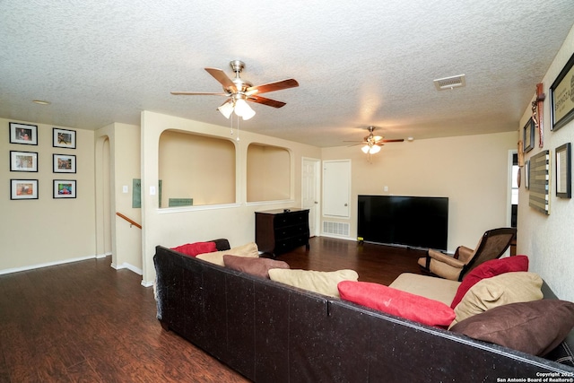 living area with visible vents, a ceiling fan, and wood finished floors