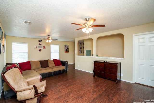 living area featuring visible vents, a textured ceiling, and ceiling fan