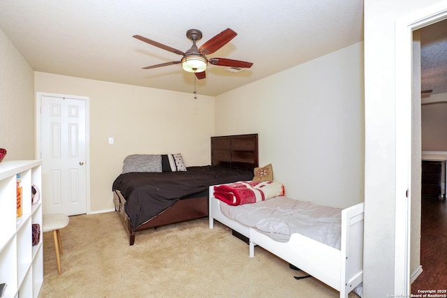 bedroom with ceiling fan and light carpet