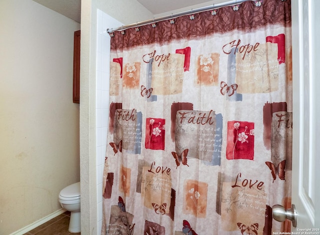 full bathroom with toilet, baseboards, a shower with shower curtain, and tile patterned flooring