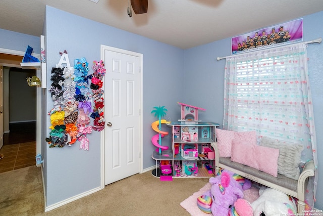 rec room featuring baseboards, a ceiling fan, and carpet