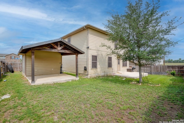 rear view of property with a fenced backyard, a patio, and a yard