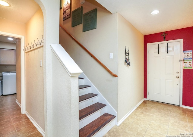tiled entryway featuring stairway, arched walkways, baseboards, and recessed lighting