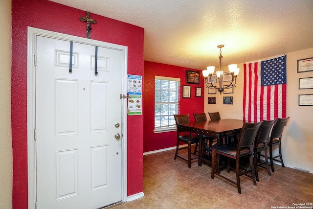dining room with a textured ceiling, baseboards, an inviting chandelier, and light tile patterned floors