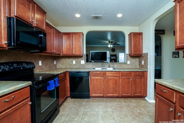 kitchen featuring a sink, arched walkways, a textured ceiling, a ceiling fan, and black appliances