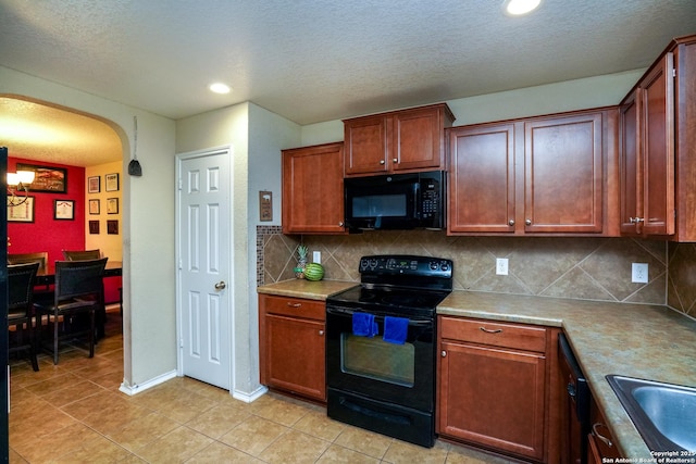 kitchen featuring arched walkways, tasteful backsplash, a sink, black appliances, and light tile patterned flooring